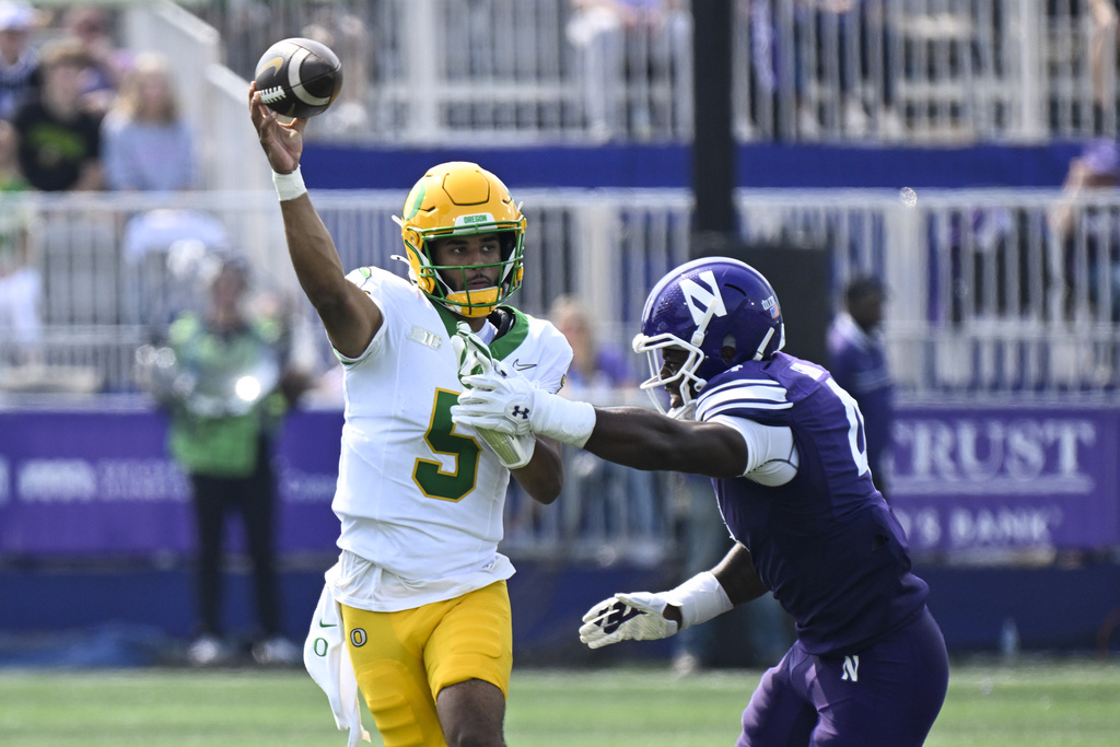 Oregon quarterback Dante Moore (5) passes against Northwestern defensive lineman Anto Saka (4) during the first half of an NCAA college football game on Saturday, Sept. 13, 2025 in Evanston, Ill. (AP Photo/Matt Marton)