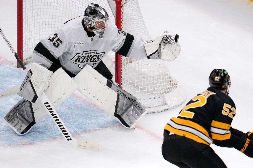 Los Angeles Kings goaltender Darcy Kuemper (35) gloves a save against Boston Bruins center Sean Kuraly (52) during the first period of an NHL hockey game, Tuesday, March 10, 2026, in Boston. (AP Photo/Charles Krupa)