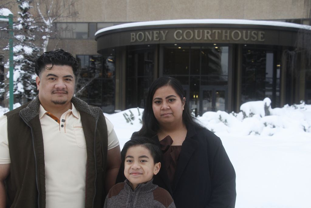 Michael Pese, left, his wife, Tupe Smith, and their son Maximus pose for a photo outside the Boney Courthouse in Anchorage, Alaska, Thursday, Jan. 15, 2026, ahead of the Alaska Court of Appeals hearing a challenge to the voter fraud case brought against her by the state. (AP Photo/Mark Thiessen)
