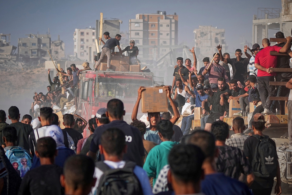 FILE -Palestinians ride on a truck loaded with food and humanitarian aid from the World Food Program, after it arrived in the northern Gaza Strip, June 16, 2025. (AP Photo/Jehad Alshrafi, File)