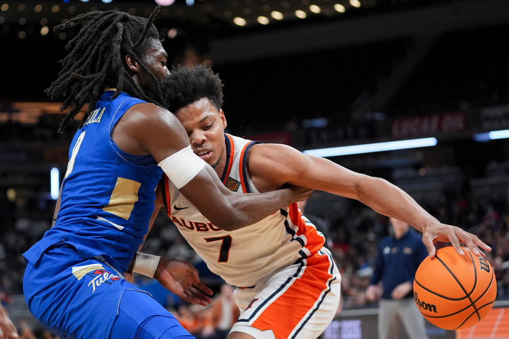 Auburn guard Keyshawn Hall (7) drives on Tulsa guard Ade Popoola during the first half of the NCAA college basketball NIT Championship game, Sunday, April 5, 2026, in Indianapolis. (AP Photo/Abbie Parr)