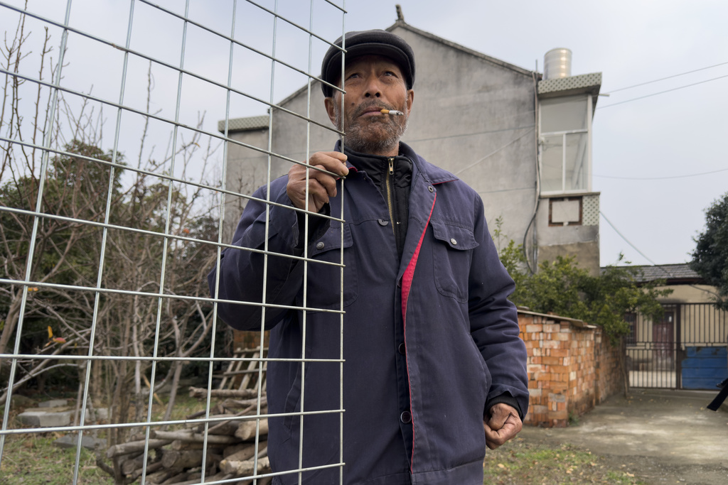 Petitioner Yang Guoliang stands at his gate outside his home in Changzhou in eastern China's Jiangsu Province, Friday, Dec. 13, 2024. (AP Photo/Ng Han Guan)