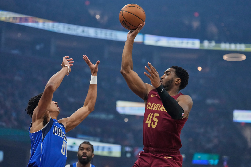 Cleveland Cavaliers guard Donovan Mitchell (45) shoots over Dallas Mavericks guard Max Christie (00) in the first half of an NBA basketball game in Cleveland, Sunday, March 15, 2026. (AP Photo/Sue Ogrocki)