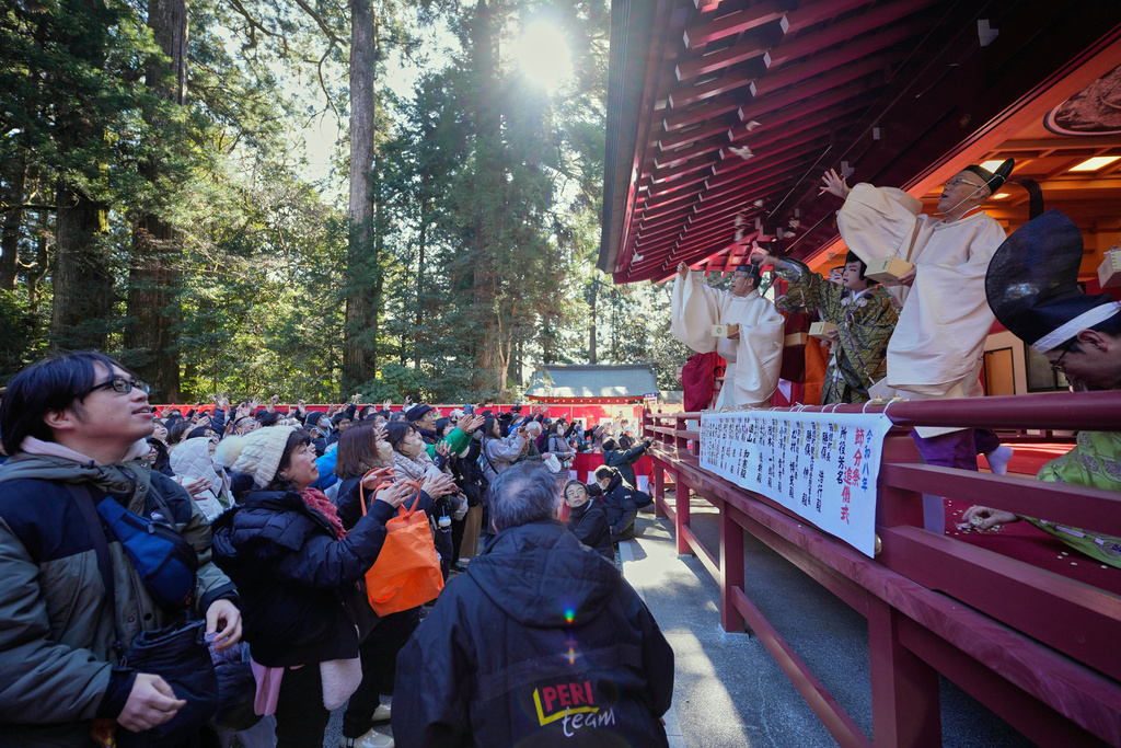 Priests and guests throw lucky beans towards the gathering at Hakone Shrine in Hakone, Japan, Tuesday, Feb. 3, 2026. (AP Photo/Eugene Hoshiko)