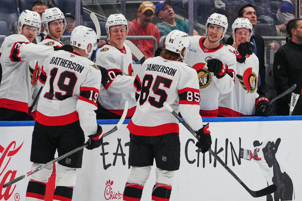 Ottawa Senators' Jake Sanderson (85) and Drake Batherson (19) celebrate with teammates after Sanderson scored a goal during the third period of an NHL hockey game against the New York Islanders Saturday, April 11, 2026, in Elmont, N.Y. (AP Photo/Frank Franklin II)