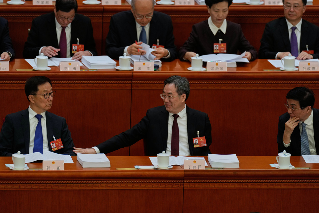 Politburo Standing Committee members from left Han Zheng, Ding Xuexiang and Wang Huning chat during the opening session of the National People's Congress (NPC) in Beijing, Thursday, March 5, 2026. (AP Photo/Ng Han Guan)