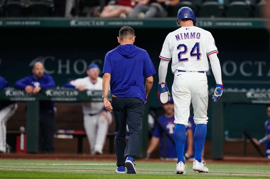 Texas Rangers' Brandon Nimmo (24) walks off the field with head athletic trainer Matt Lucero after suffering an unknon injury in the fifth inning of a baseball game against the Texas Rangers Wednesday, April 29, 2026, in Arlington, Texas. (AP Photo/Tony Gutierrez)