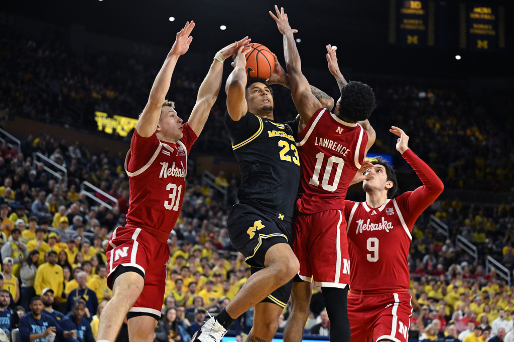 Michigan forward Yaxel Lendeborg (23) shoots the ball between Nebraska guard Cale Jacobsen (31) and Nebraska guard Jamarques Lawrence (10) in the second half of an NCAA college basketball game in Ann Arbor, Mich., Tuesday, Jan. 27, 2026. (AP Photo/Lon Horwedel)