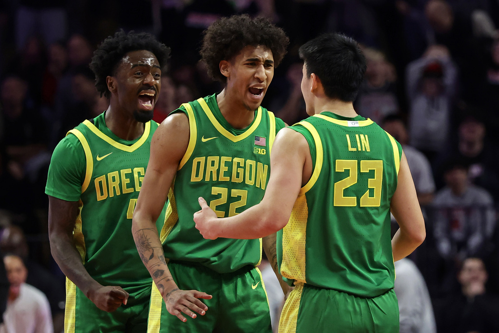 Oregon guard Wei Lin (23) celebrates with forward Devon Pryor (22) after hitting a 3-point basket to send an NCAA college basketball game against Rutgers into overtime Monday, Jan. 5, 2026, in Piscataway, N.J. (AP Photo/Adam Hunger)