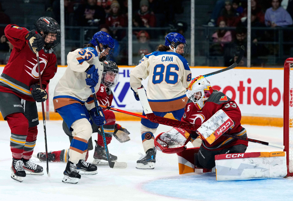 Ottawa Charge goaltender Gwyneth Philips (33) looks for the save in front of Vancouver Goldeneyes' Michelle Karvinen (33) and Michela Cava (86) during second period PWHL hockey action in Ottawa, on Wednesday, Nov. 26, 2025. (Justin Tang/The Canadian Press via AP)