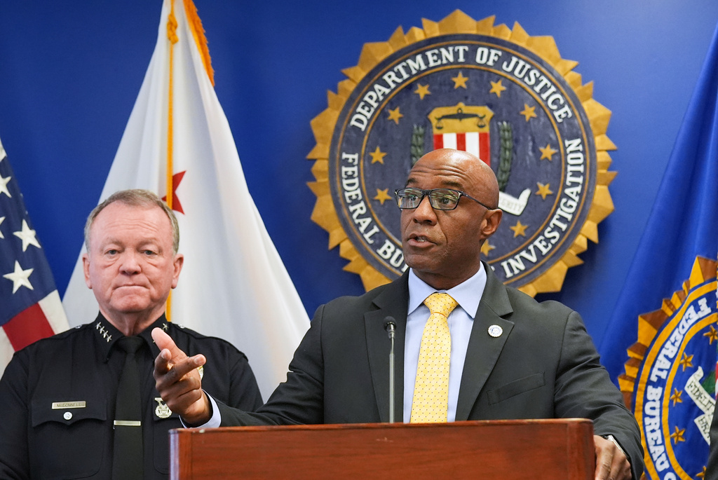 FBI Assistant Director in Charge Akil Davis, right, speaks in front of LAPD Chief Jim McDonnell while announcing developments on a terrorism investigation during a press conference Monday, Dec. 15, 2025, in Los Angeles. (AP Photo/Damian Dovarganes)
