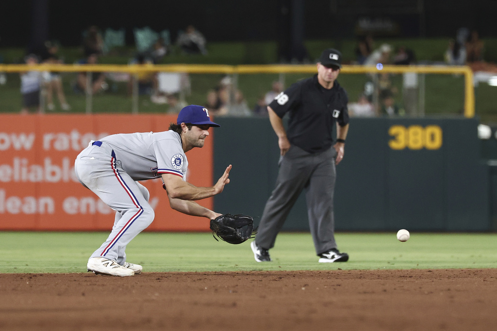 Texas Rangers shortstop Josh Smith fields the ball during the eighth inning of a baseball game against the Athletics, Friday, Aug. 29, 2025, in West Sacramento, Calif. (AP Photo/Sara Nevis)