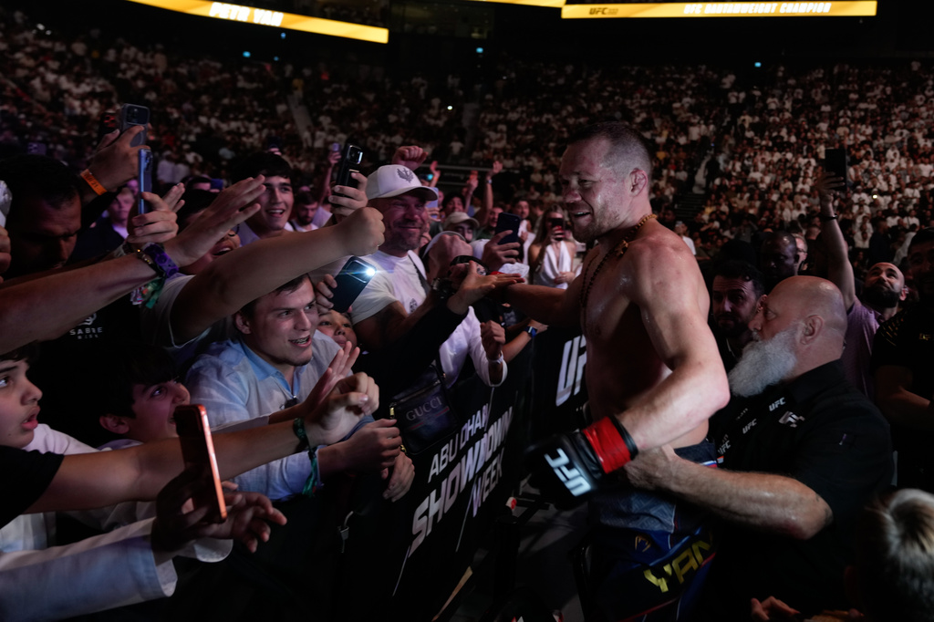 Russia's Petr Yan, right, celebrates with his fans after beating Merab Dvalishvili of Georgia to win the Bantamweight title bout at the mixed martial arts UFC Fight Night on Saturday, Oct. 24, 2026. (AP Photo/Altaf Qadri)