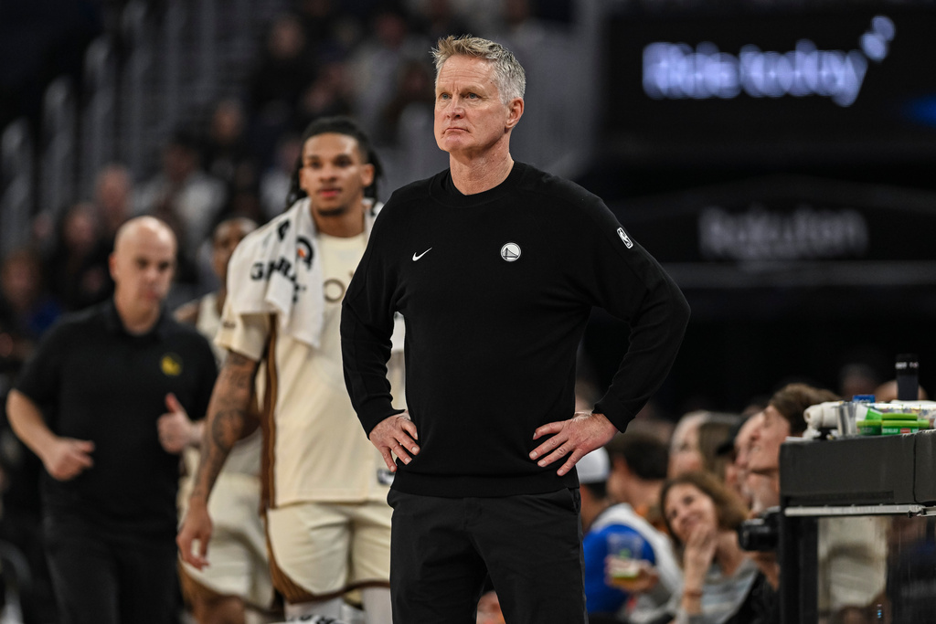 Golden State Warriors head coach Steve Kerr, center, looks on during the first half of an NBA basketball game against the Orlando Magic, Monday, Dec. 22, 2025, in San Francisco (AP Photo/Justine Willard)