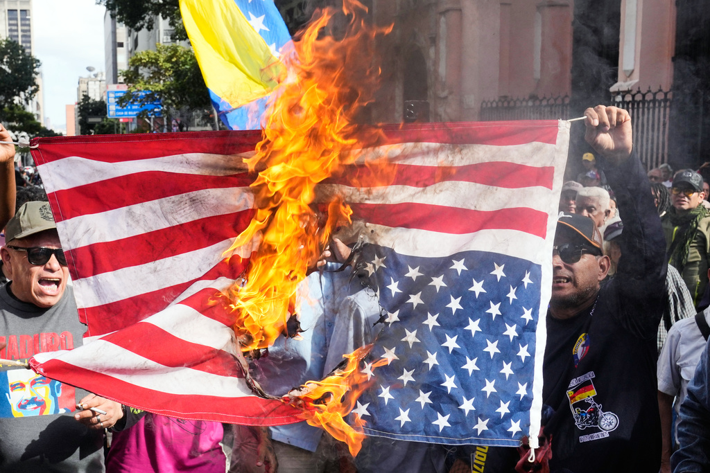 Government supporters burn a U.S. flag in Caracas, Venezuela, Saturday, Jan. 3, 2026, after U.S. President Donald Trump announced that U.S. forces had captured Venezuelan President Nicolás Maduro and his wife. (AP Photo/Ariana Cubillos)