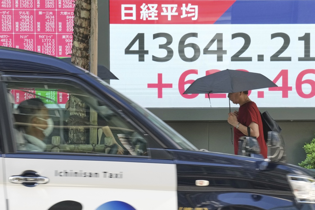 A person walks in front of an electronic stock board showing Japan's Nikkei index at a securities firm Monday, Sept. 8, 2025, in Tokyo. (AP Photo/Eugene Hoshiko)