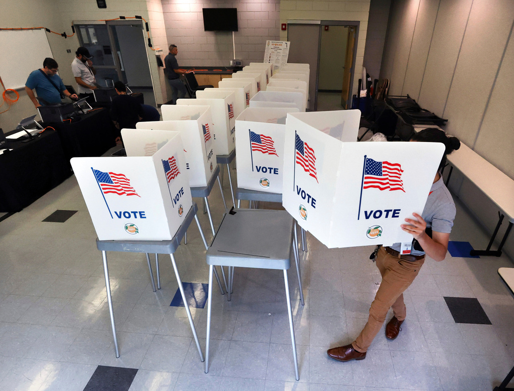 FILE - Lenny Carrillo, from the Orange County Supervisor of Elections Office, sets up voting booths at the Meadow Woods Community Center in Orlando, Fla., Oct. 15, 2024. (Joe Burbank/Orlando Sentinel via AP, File)
