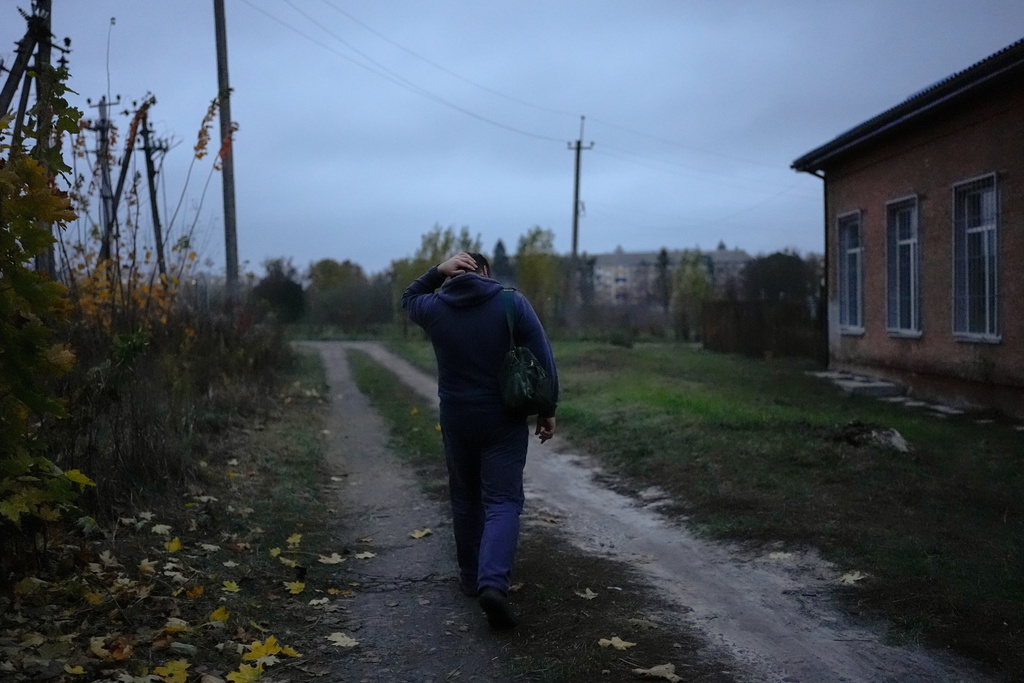 CORRECTS FAMILY NAME TO ADAMCHUK - Oleksandr Adamchuk walks from base to his family's house at dusk, following a long day of work, Friday, Oct. 24, 2025, in Kyiv region, Ukraine. (AP Photo/Julia Demaree Nikhinson)
