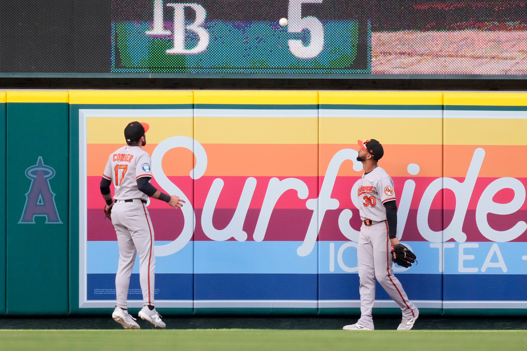 Baltimore Orioles center fielder Colton Cowser, left, and right fielder Leody Taveras watch as a ball hit by Los Angeles Angels' Nolan Schanuel goes out for a two-run home run during the first inning of a baseball game Tuesday, June 23, 2026, in Anaheim, Calif. (AP Photo/Mark J. Terrill)