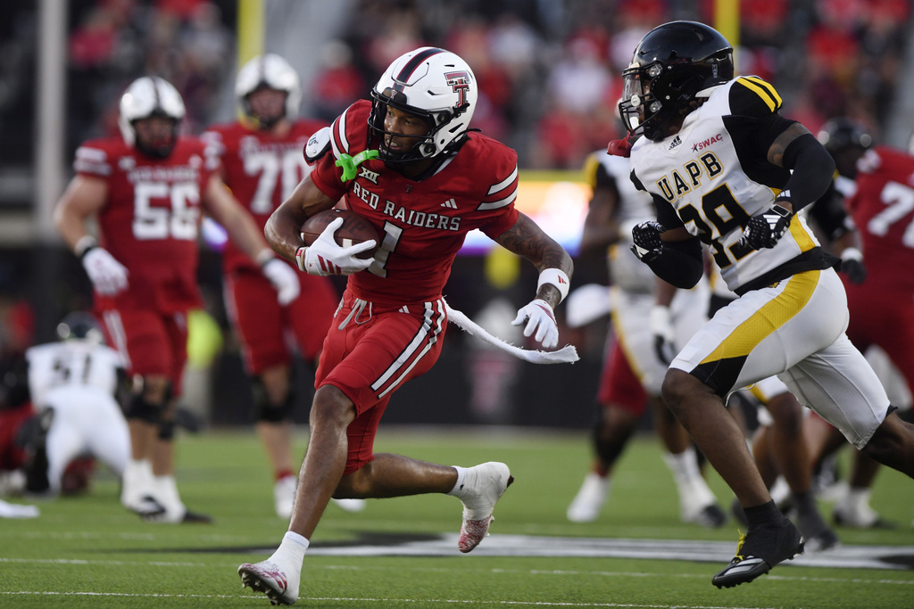 Texas Tech wide receiver Reggie Virgil (1) runs with the ball while Arkansas-Pine Bluff defensive back Amyrion Mingo (39) attempts to tackle during the first half of an NCAA college football game, Saturday, Aug. 30, 2025, in Lubbock, Texas. (AP Photo/Annie Rice)