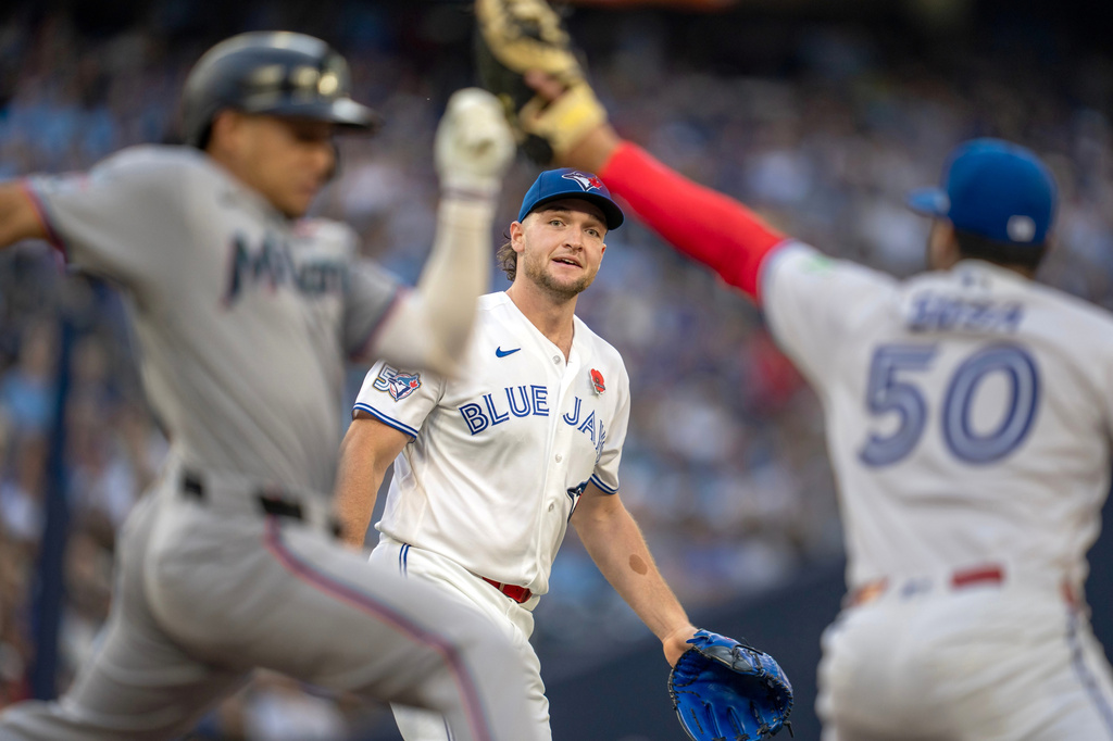 Toronto Blue Jays pitcher Trey Yesavage, center, watches as his throw to first baseman Lenyn Sosa (50) puts out Miami Marlins' Javier Sanoja, left, during first-inning baseball game action in Toronto, Monday May 25, 2026. (Frank Gunn/The Canadian Press via AP)