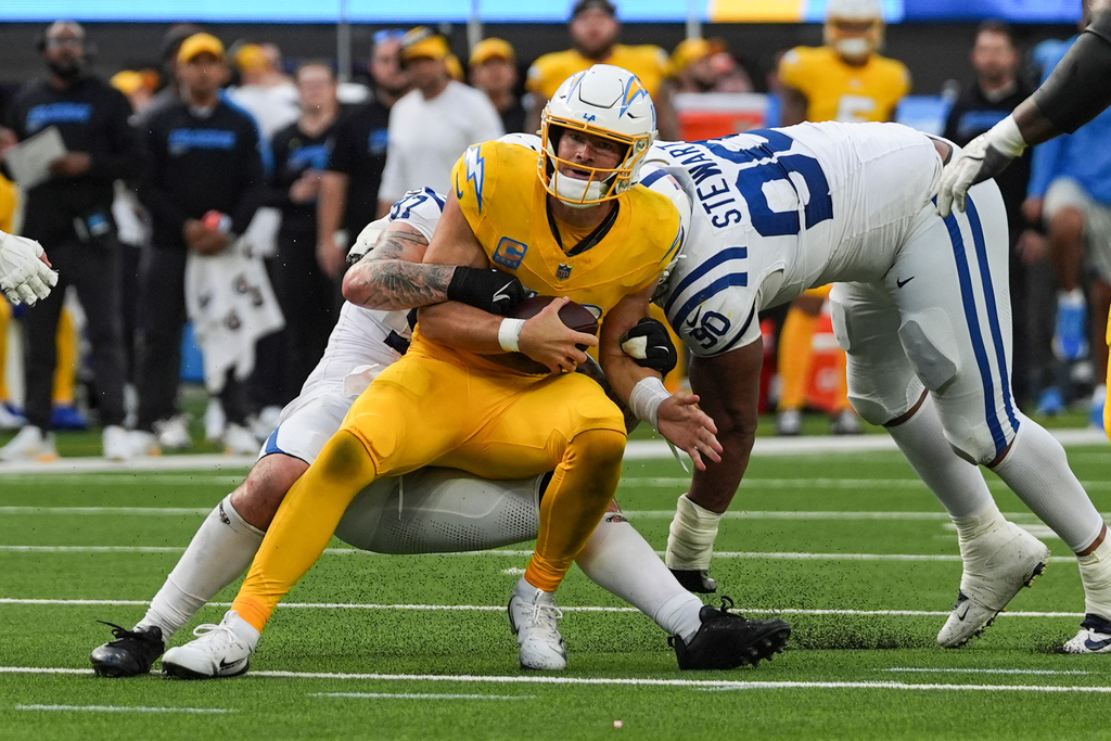 Los Angeles Chargers quarterback Justin Herbert (10) is tackled by Indianapolis Colts defensive end Laiatu Latu (97) and defensive tackle Grover Stewart (90) during the second half of an NFL football game Sunday, Oct. 19, 2025, in Inglewood, Calif. (AP Photo/Gregory Bull)