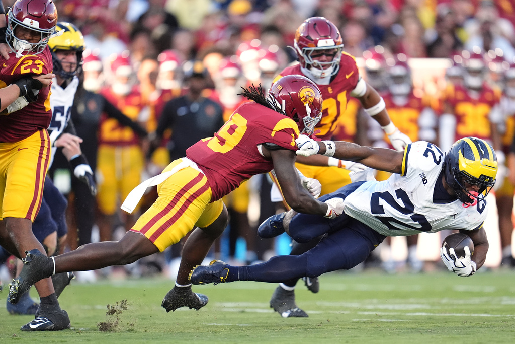 Michigan running back Justice Haynes (22) is tackled by Southern California safety Bishop Fitzgerald (19) during the first half of an NCAA college football game Saturday, Oct. 11, 2025, in Los Angeles. (AP Photo/Marcio Jose Sanchez)