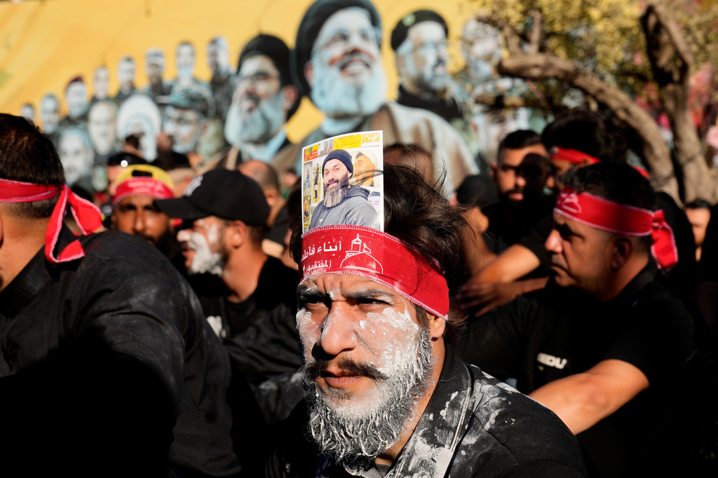A Hezbollah supporter with mud on his face brought from Karbala, attends the holy day of Ashoura that commemorates the 7th century martyrdom of the Prophet Muhammad's grandson Hussein, in Dahiyeh, Beirut's southern suburbs, Lebanon, Friday, June 26, 2026. (AP Photo/Hussein Malla)