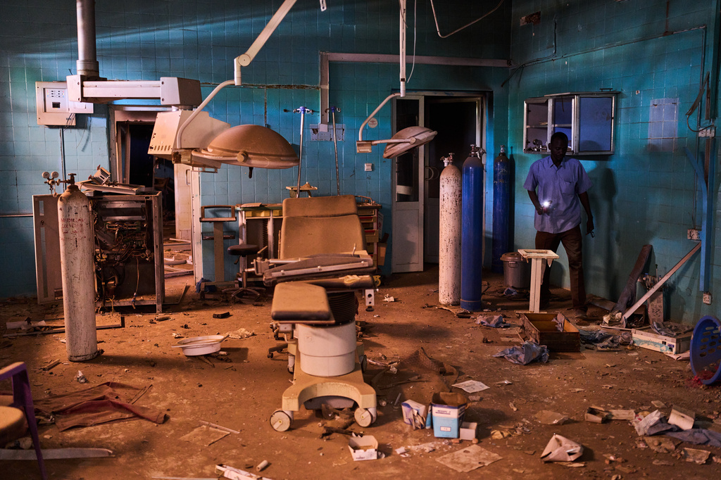 A guard walks through a war-damaged section of Al Shaabi Hospital in Khartoum, Saturday, April 18, 2026. (AP Photo/Bernat Armangue)