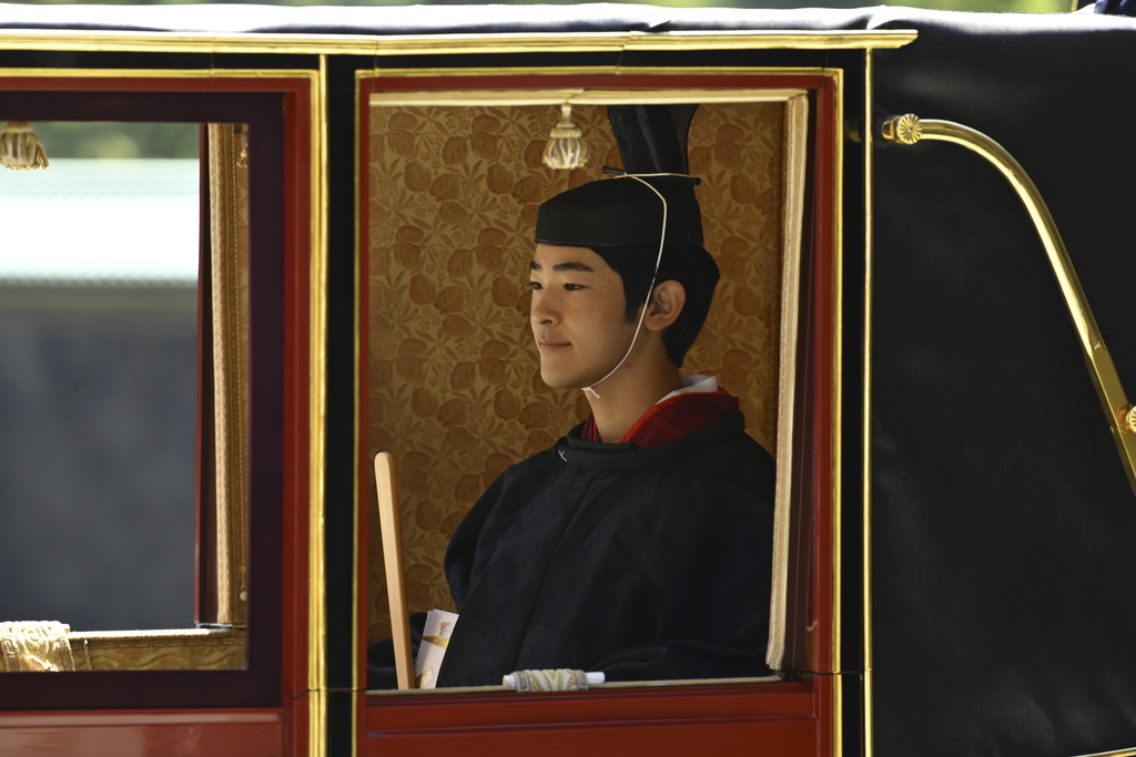 Japan's Prince Hisahito, in traditional attire, is seen inside a horse-drawn carriage as he leaves the Imperial Palace after attending his coming-of-age ceremony to be recognized as an adult, on his 19th birthday in Tokyo, Saturday, Sept. 6, 2025. (David Mareuil/Pool Photo via AP)