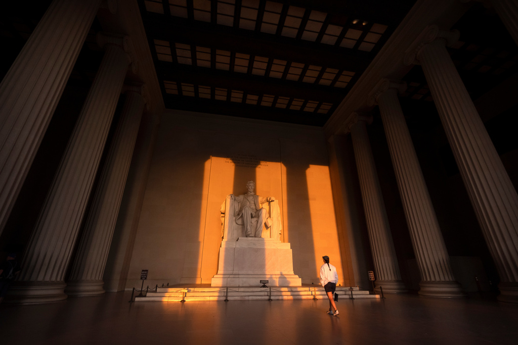 A visitor walks at the Lincoln Memorial at sunrise on Wednesday, Oct. 1, 2025, in Washington. (AP Photo/Mark Schiefelbein)