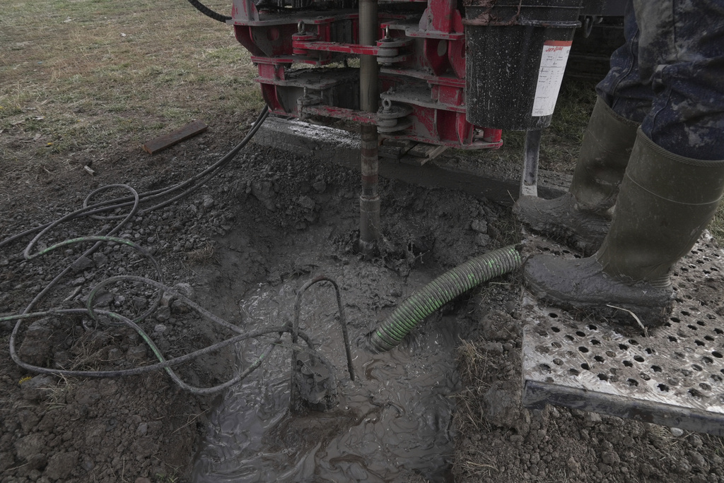 A drill bit spins into the earth during a geothermal heat pump installation Thursday, Oct. 9, 2025, in Hamilton, Colo. (AP Photo/Brittany Peterson)