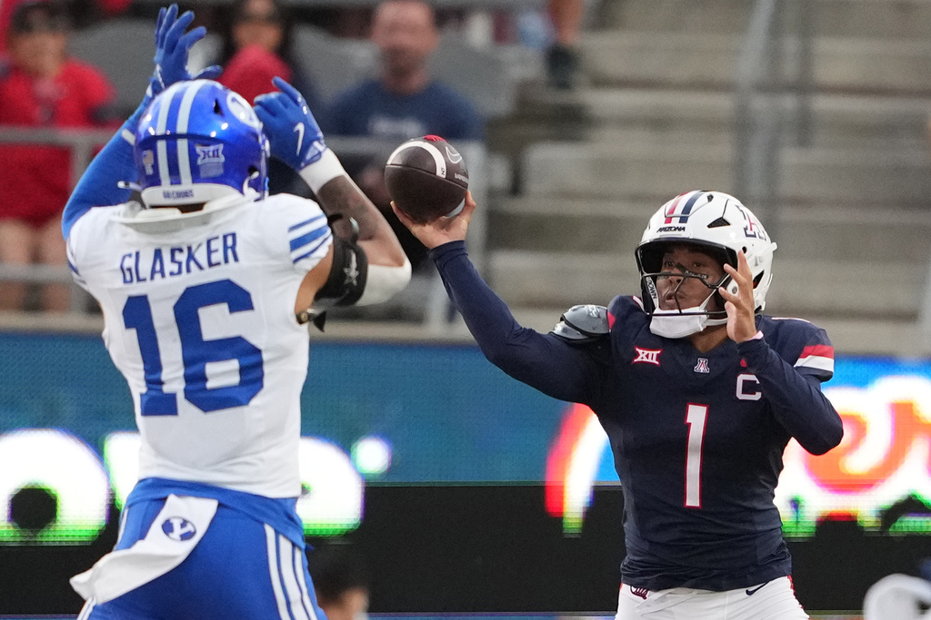 Arizona quarterback Noah Fifita throws the ball past BYU linebacker Isaiah Glasker (16) in the first half of an NCAA college football game Saturday, Oct. 11, 2025, in Tucson, Ariz. (AP Photo/Rick Scuteri)