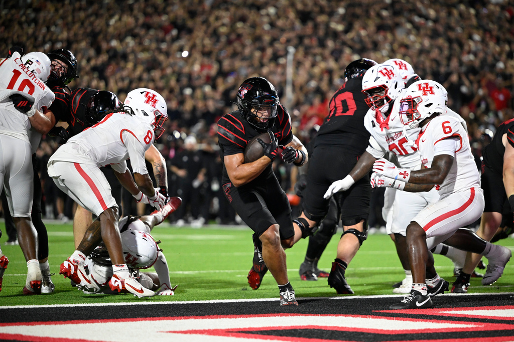 Texas Tech running back Cameron Dickey, center, runs the ball in for a touchdown against Houston during the second half of an NCAA college football game Friday, Sept. 18, 2026, in Lubbock, Texas. (AP Photo/Justin Rex)