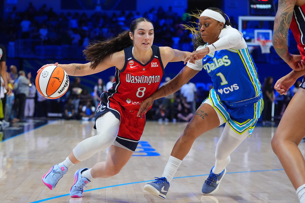 Washington Mystics guard Georgia Amoore (8) drives against Dallas Wings guard Odyssey Sims (1) during the first half of a WNBA basketball game in Arlington, Texas, Monday, May 18, 2026. (AP Photo/LM Otero)