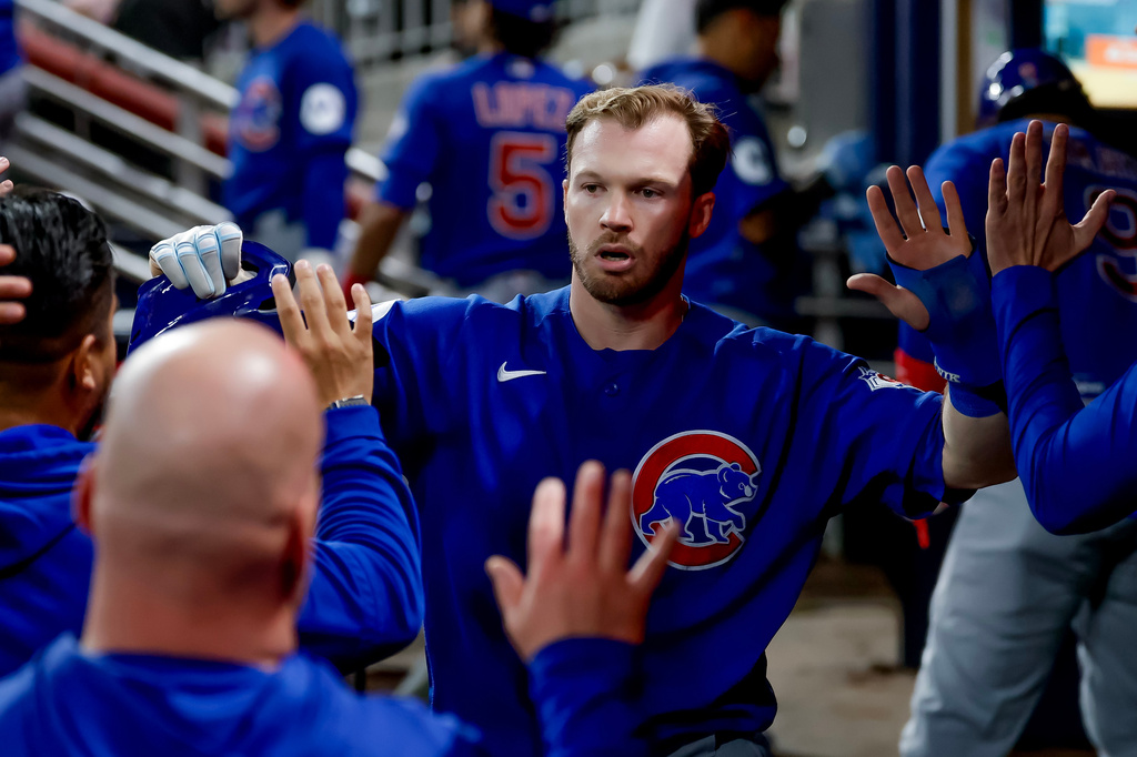 Chicago Cubs' Ian Happ is greeted in the dugout after scoring against the Atlanta Braves during the sixth inning of a baseball game, Thursday, May 14, 2026, in Atlanta. (AP Photo/Erik S. Lesser)
