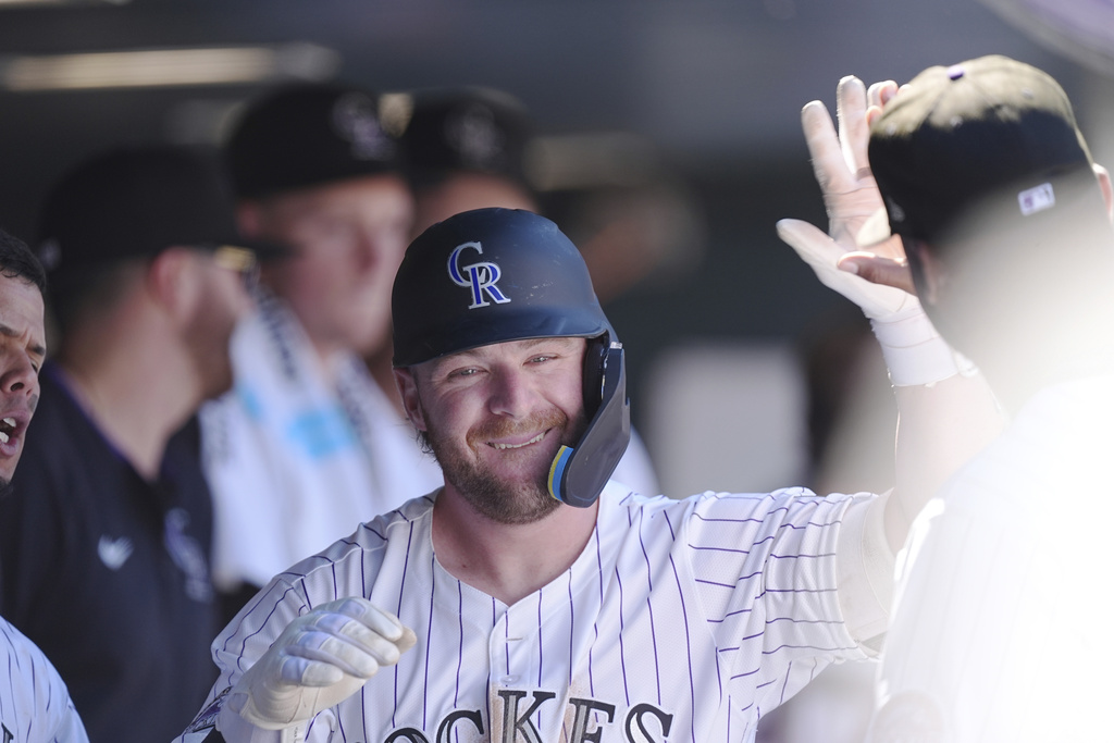 Colorado Rockies' Blaine Crim is congratulated as he returns to the dugout after hitting a solo home run off Los Angeles Angels starting pitcher Caden Dana in the fourth inning of a baseball game Sunday, Sept. 21, 2025, in Denver. (AP Photo/David Zalubowski)