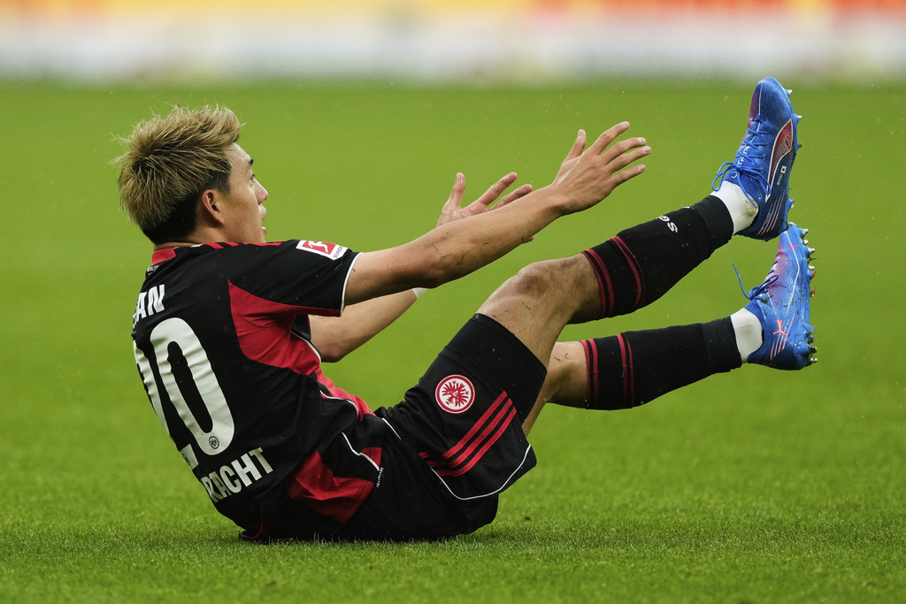 Frankfurt's Ritsu Doan is on the ground during a German Bundesliga soccer match between Eintracht Frankfurt and Union Berlin in Frankfurt, Germany, Sunday, Sept. 21, 2025. (AP Photo/Michael Probst)