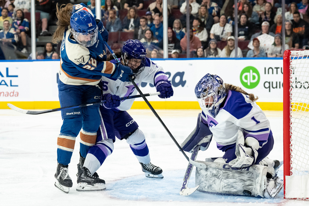 Minnesota Frost goaltender Marlene Boissonnault (1) stops Vancouver Goldeneyes' Abby Boreen (22) as Frost's Sidney Morin (5) defends during the third period of a PWHL hockey game in Vancouver, British Columbia, Saturday, April 25, 2026. (Ethan Cairns/The Canadian Press via AP)