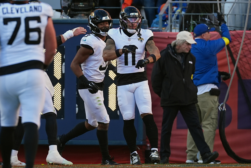 Jacksonville Jaguars wide receiver Parker Washington (11) celebrates after scoring a touchdown against the Denver Broncos during the first half of an NFL football game in Denver, Sunday, Dec. 21, 2025. (AP Photo/David Zalubowski)