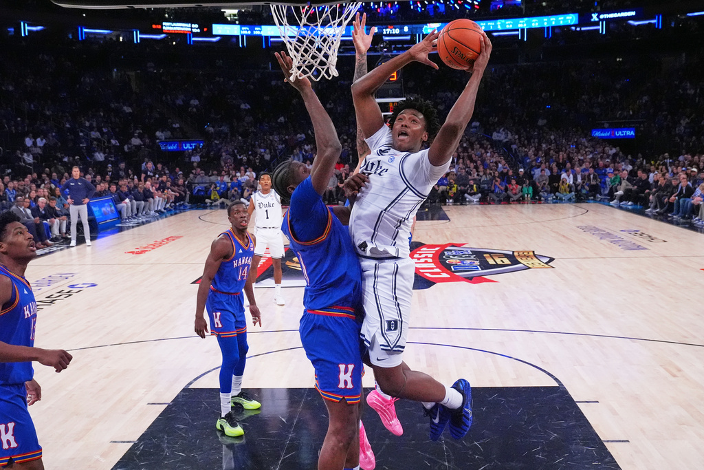 Duke's Patrick Ngongba, right, shoots over Kansas' Flory Bidunga during the first half of an NCAA college basketball game Tuesday, Nov. 18, 2025, in New York. (AP Photo/Frank Franklin II)