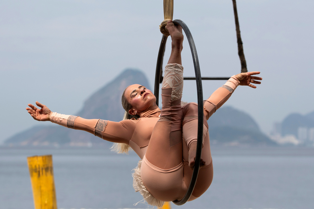 A member of the group aerial circus "Pendurados” performs in an open-air show that explores healing from sexual violence through art and community, at Icarai Beach in Niteroi, Rio de Janeiro state, Brazil, Saturday, Oct. 18, 2025. (AP Photo/Bruna Prado)