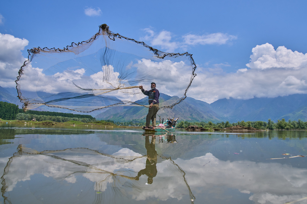 Abdul Rasheed, a fisher, casts his net into the waters of Wular Lake in Bandipora, northeast of Srinagar, Indian controlled Kashmir, Tuesday, May 5, 2026. (AP Photo/Dar Yasin)