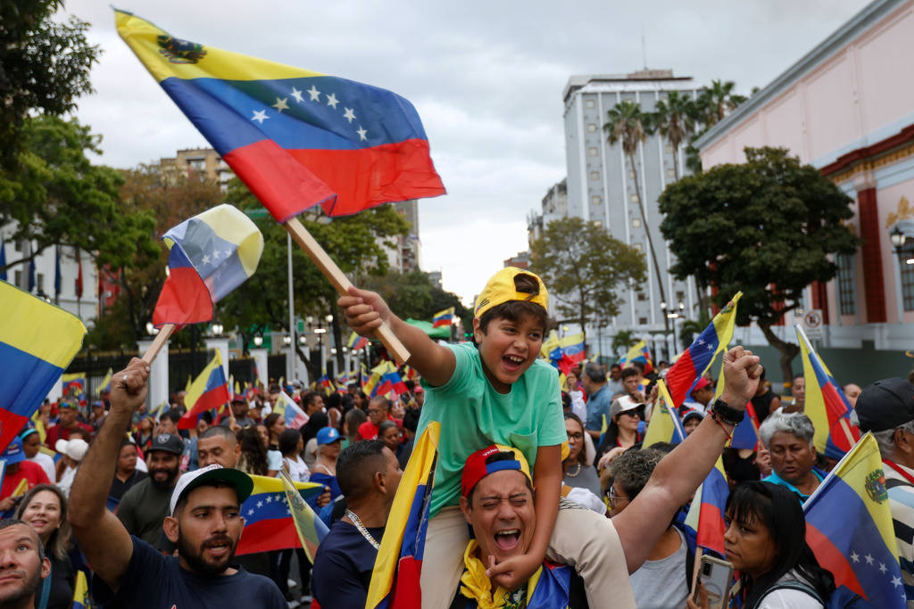 Venezuela fans celebrate a day after their team's victory over the United States in the championship match of the World Baseball Classic, at the Miraflores presidential palace in Caracas, Venezuela, Wednesday, March 18, 2026. (AP Photo/Pedro Mattey)
