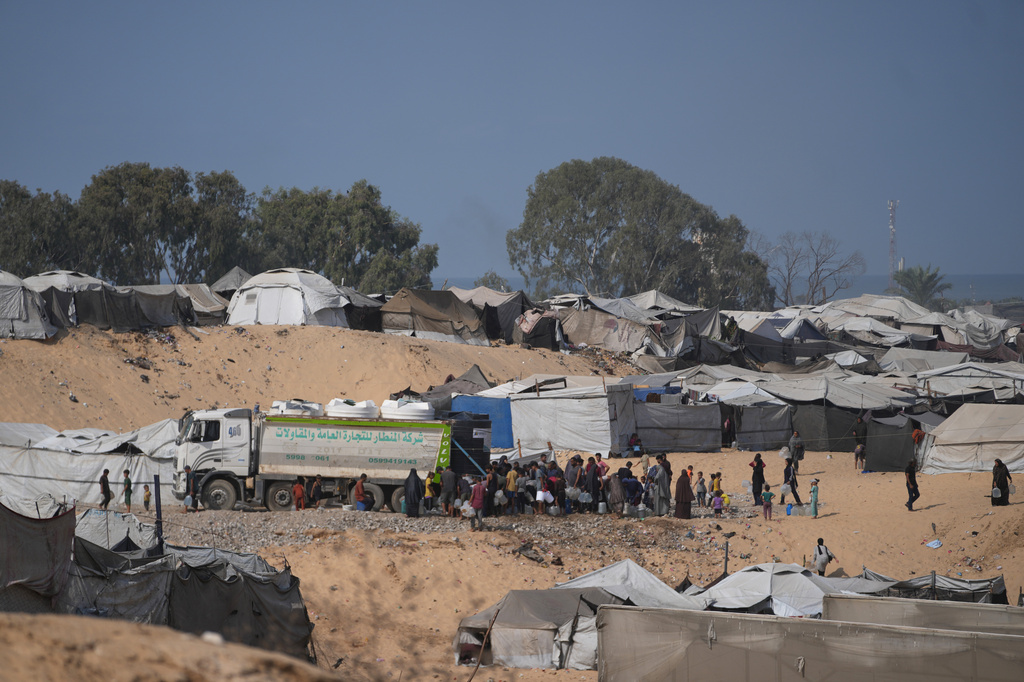 Displaced Palestinians gather to fill containers with fresh water from a supplier in Deir al-Balah, central Gaza Strip, Saturday, Oct. 10, 2026. (AP Photo/Abdel Kareem Hana)