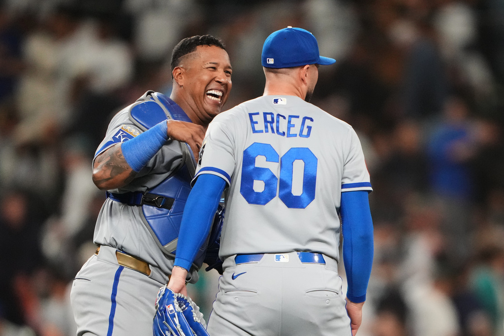 Kansas City Royals catcher Salvador Perez celebrates with relief pitcher Lucas Erceg (60) after a win over the Seattle Mariners in a baseball game, Friday, May 1, 2026, in Seattle. (AP Photo/Lindsey Wasson)