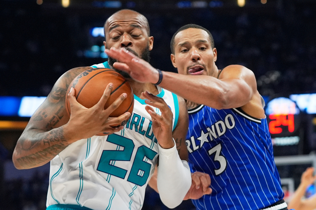 Charlotte Hornets forward Xavier Tillman (26) and Orlando Magic guard Desmond Bane (3) during the second half of an NBA play-in tournament basketball game, Friday, April 17, 2026, in Orlando, Fla. (AP Photo/John Raoux)