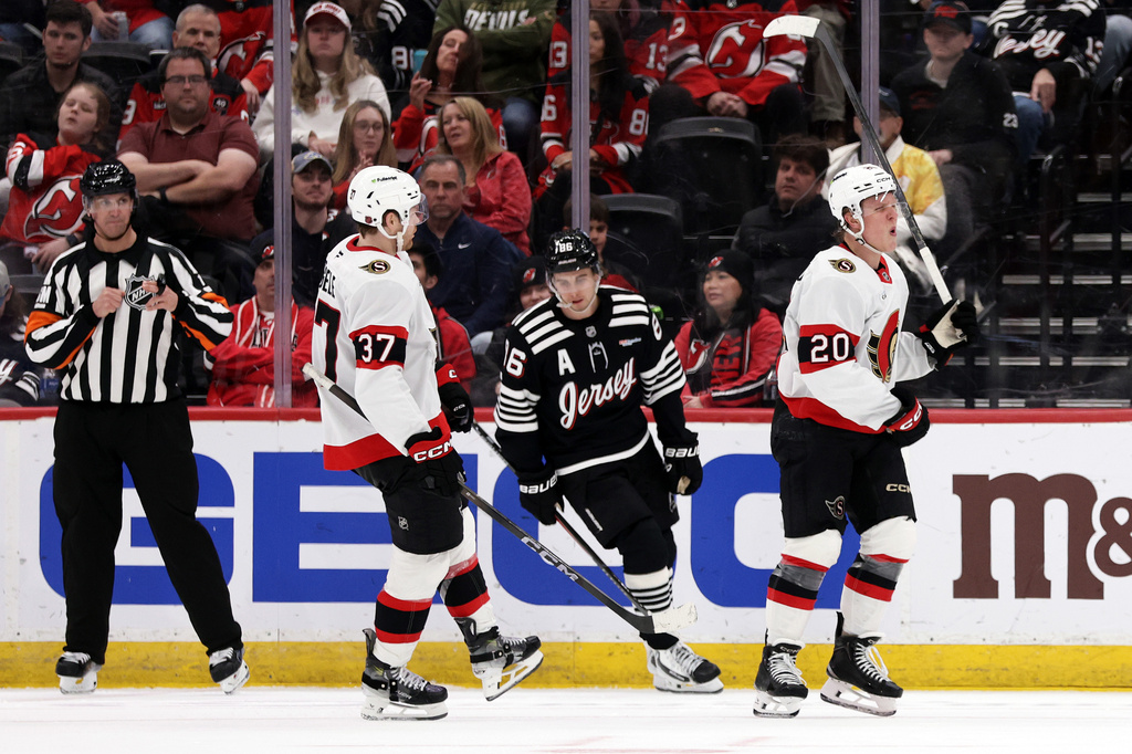 Ottawa Senators left wing Fabian Zetterlund (20) reacts after scoring in front of New Jersey Devils center Jack Hughes (86) during the second period of an NHL hockey game Sunday, April 12, 2026, in Newark, N.J. (AP Photo/Adam Hunger)