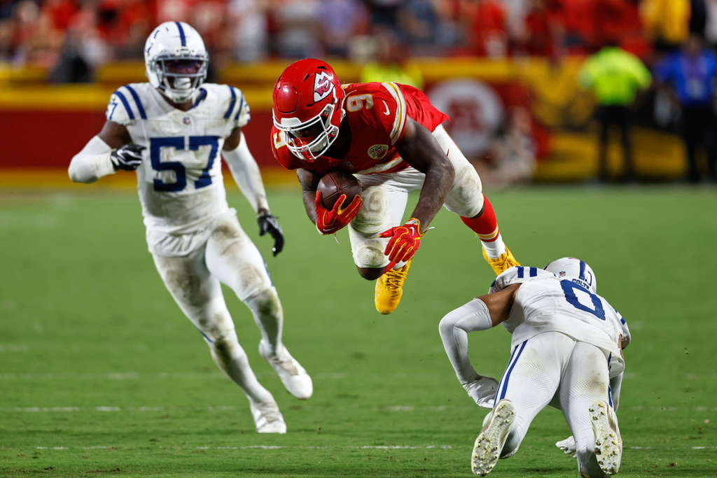 Kansas City Chiefs running back Kenneth Walker III (9) is upended by Indianapolis Colts safety Cam Bynum (0) as Colts linebacker Jaylon Carlies (57) watches during overtime of an NFL football game Sunday, Sept. 20, 2026, in Kansas City, Mo. (AP Photo/Colin E. Braley)