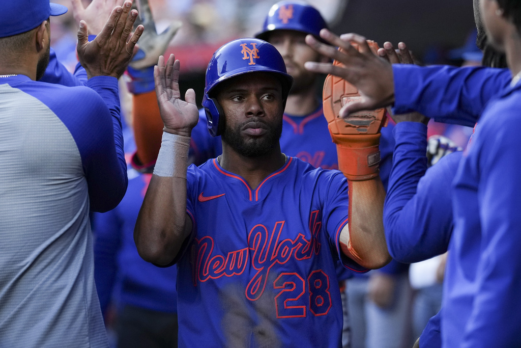 New York Mets' Cedric Mullins (28) celebrates with teammates after scoring on a sacrifice fly ball hit by teammate Brandon Nimmo during the third inning of a baseball game against the Cincinnati Reds, Saturday, Sept. 6, 2025, in Cincinnati. (AP Photo/Jeff Dean)